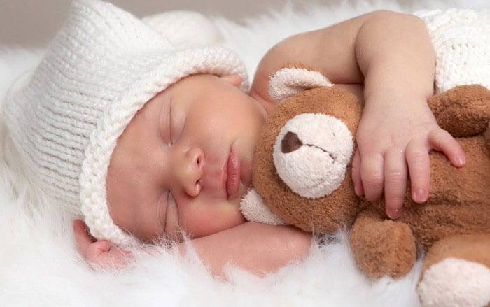 Новорожденный спит с мягкой игрушкой